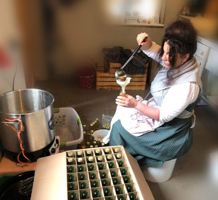 Manuela beim Abfüllen der Kräuterkraft-Öle in der Einkochküche ihres Bauernhofes