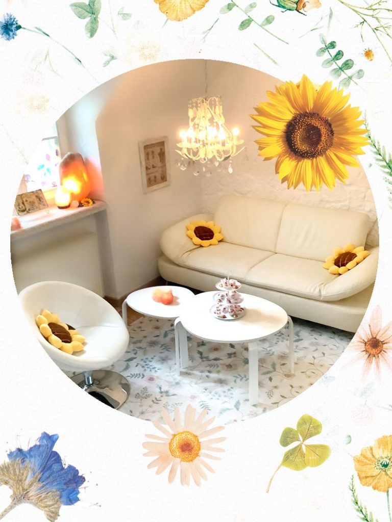 Sofalaunch, heller Wohnraum mit Sofas, einem Tisch und Sonnenblumen-Dekoration.